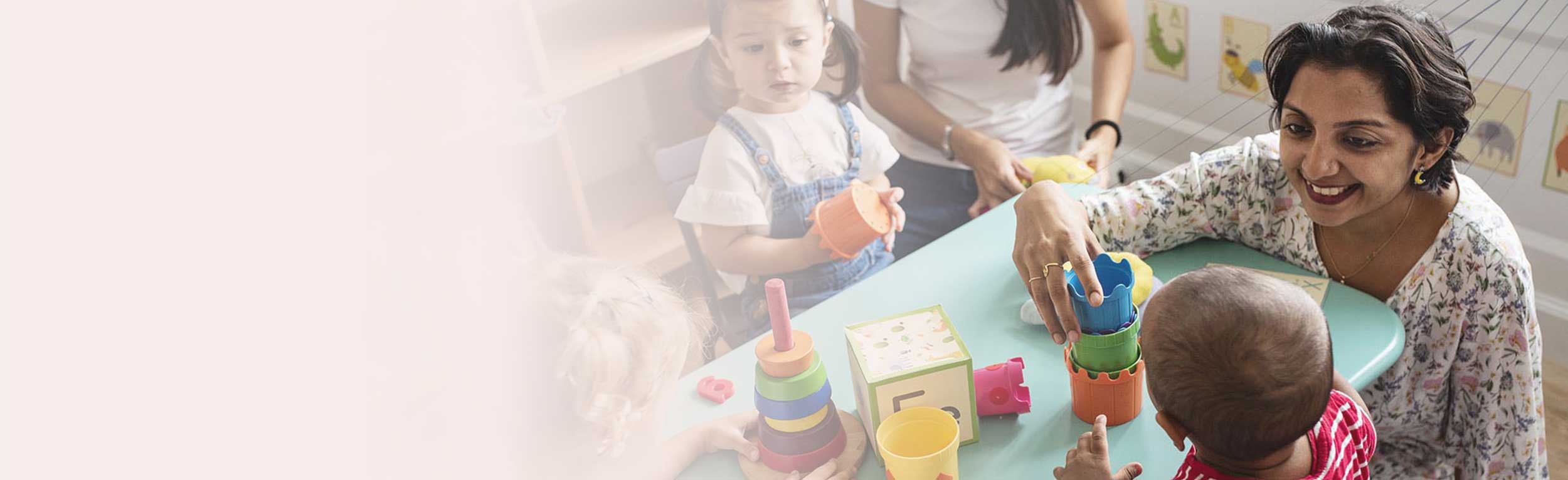 Nursery children playing with teacher in the classroom